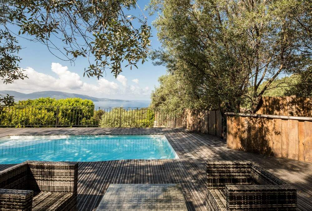 Résidence de luxe avec piscine, terrasse en bois et vue panoramique sur la mer