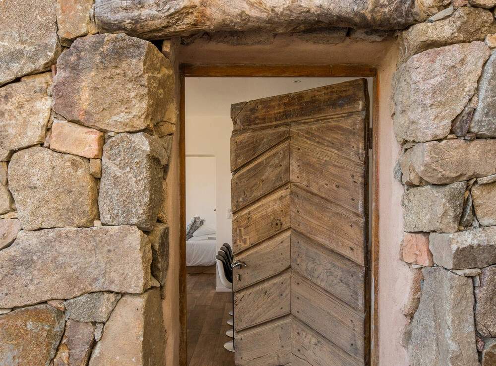 Porte en bois massif d'une résidence de luxe avec encadrement en pierre