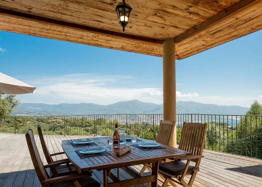 Villa luxe avec terrasse panoramique, table en bois et vue sur montagnes