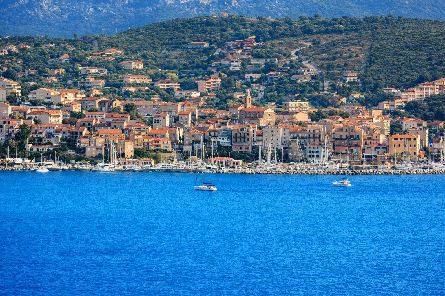 Propriano, port méditerranéen de Corse avec maisons colorées et voiliers ancrés