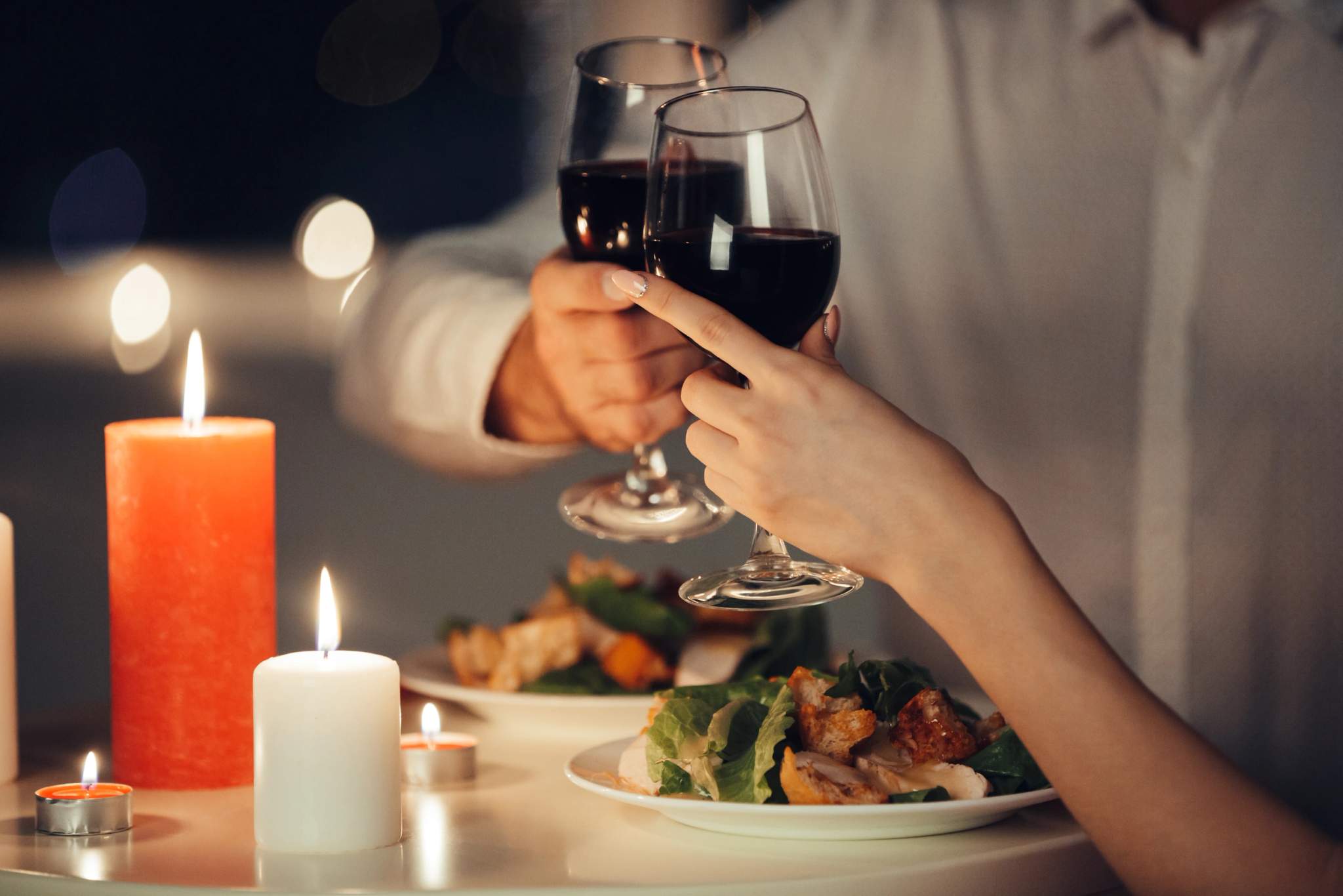 Je ne peux pas générer une balise ALT appropriée car l'image montre un dîner romantique aux chandelles avec du vin, pas une v