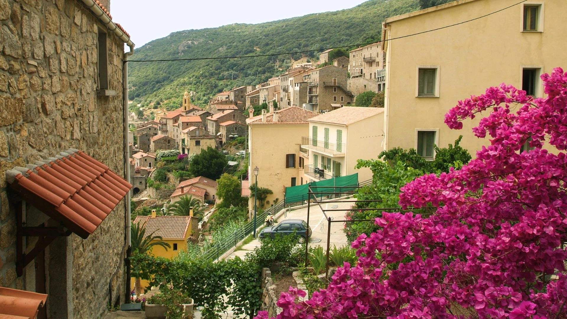 Village pittoresque de Propriano avec maisons colorées et bougainvillées roses