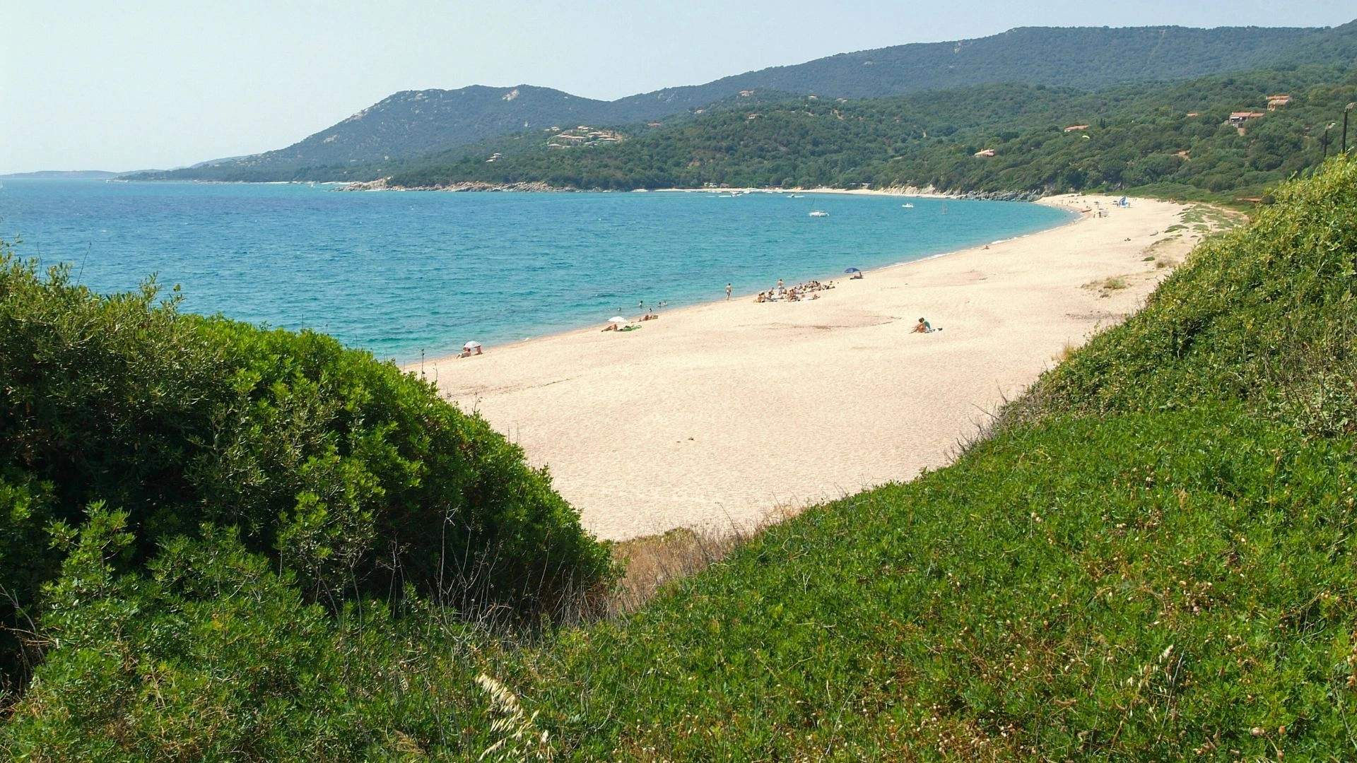 Plage de sable blanc de Propriano en Corse avec mer turquoise et montagnes boisées