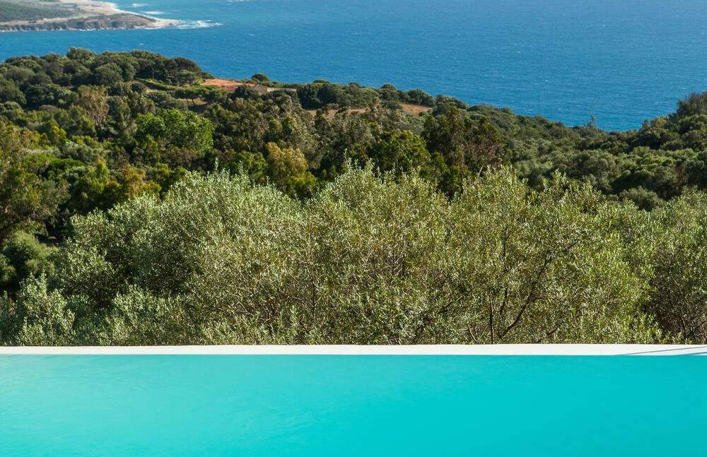 Vue aérienne d'une résidence de luxe avec piscine turquoise face à la Méditerranée