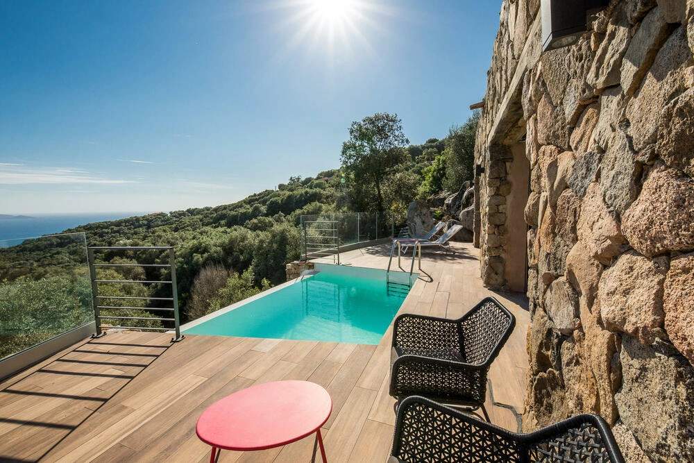 Résidence de luxe méditerranéenne avec piscine turquoise, vue mer et terrasse en bois