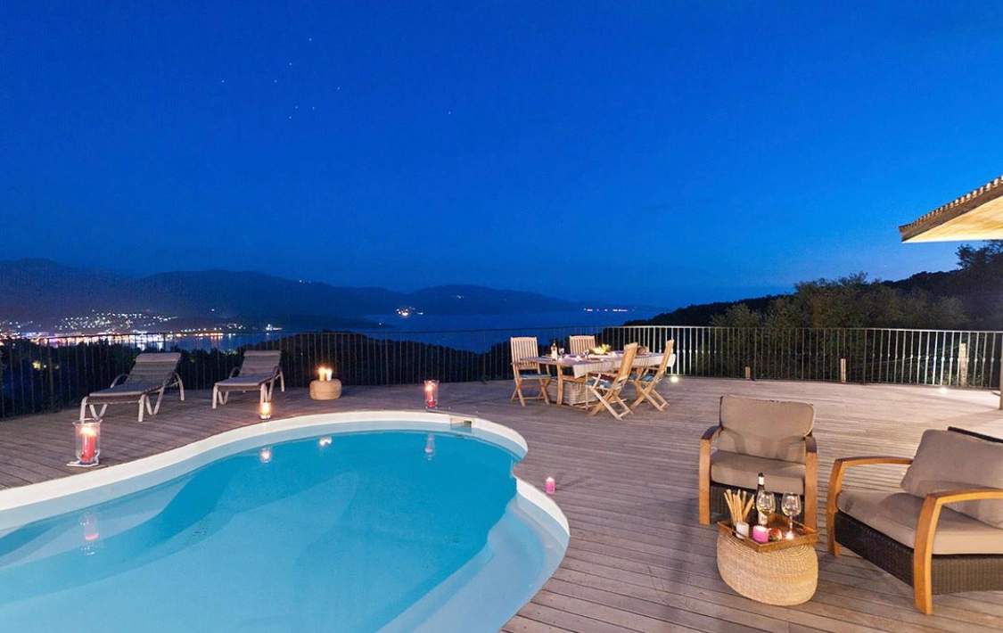 Résidence de luxe avec piscine, terrasse et vue panoramique sur la mer au crépuscule