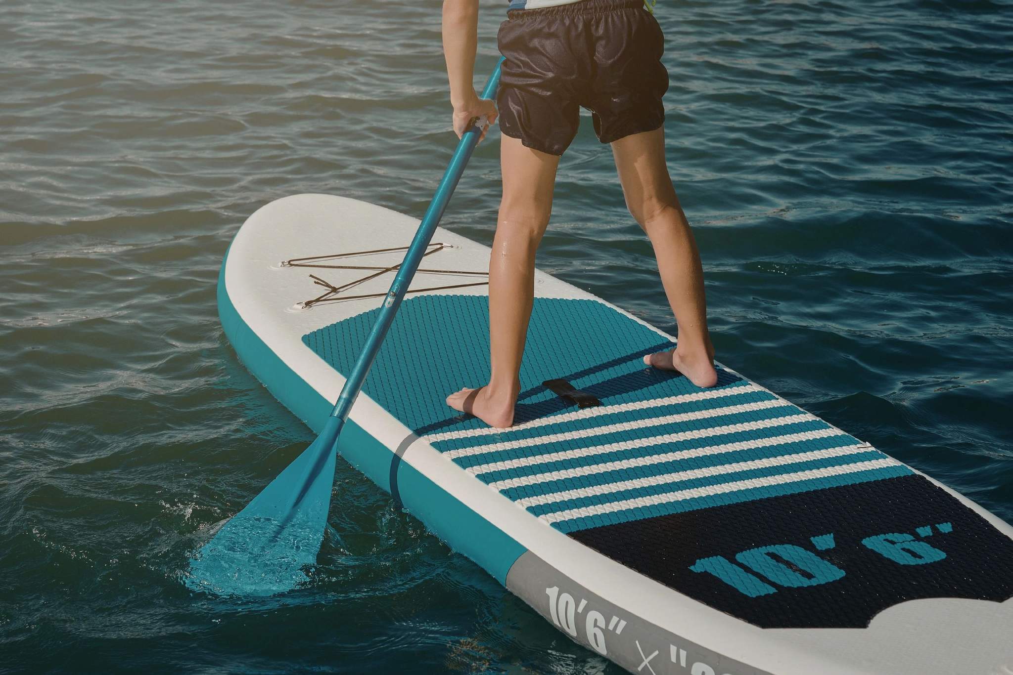 Un paddleboard turquoise à Propriano avec pagaie dans les eaux claires de Corse